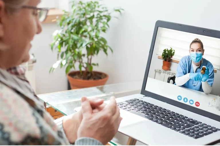 Woman consulting doctor via computer.