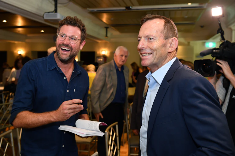 Johannes Leak signs a book for Tony Abbott during a book launch.