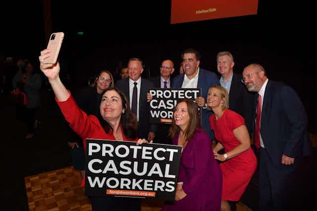Terri Butler takes a selfie with Anthony Albanese, and several others, carrying signs which read "Protect Casual Workers"