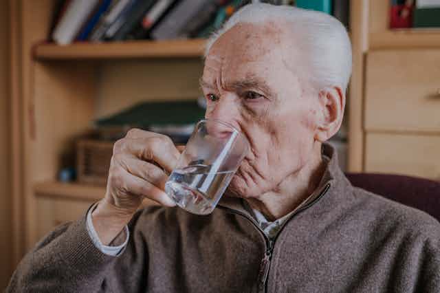 A man taking a tablet with water