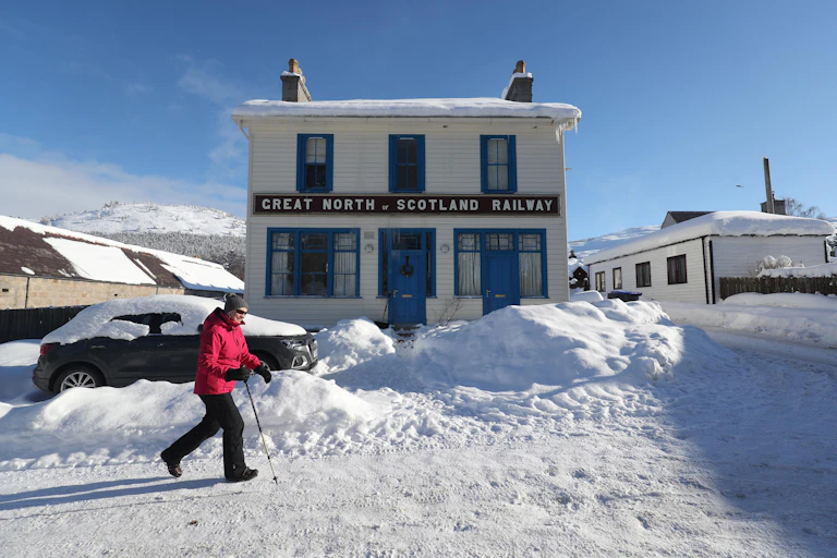 Woman walks down snowy street