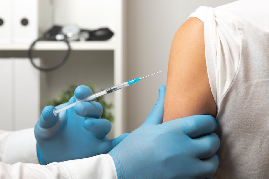 Doctor administers a vaccine into a person's arm.