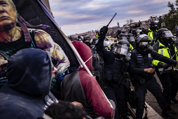 A mob is fought back by police