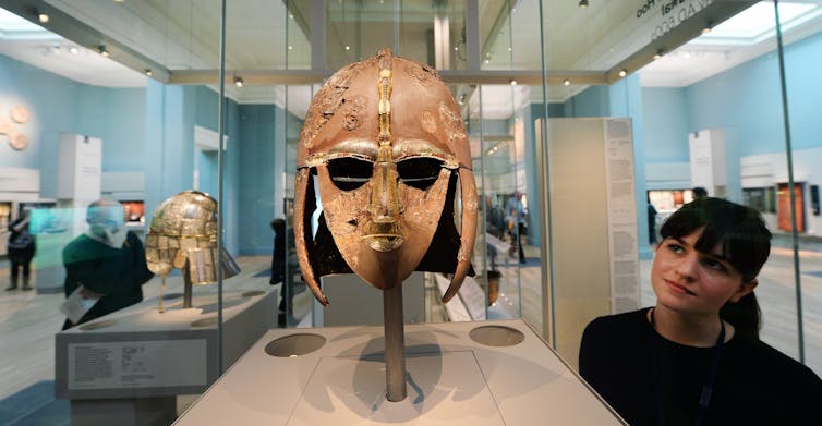 A woman looks at the Sutton Hoo helmet at the British Museum