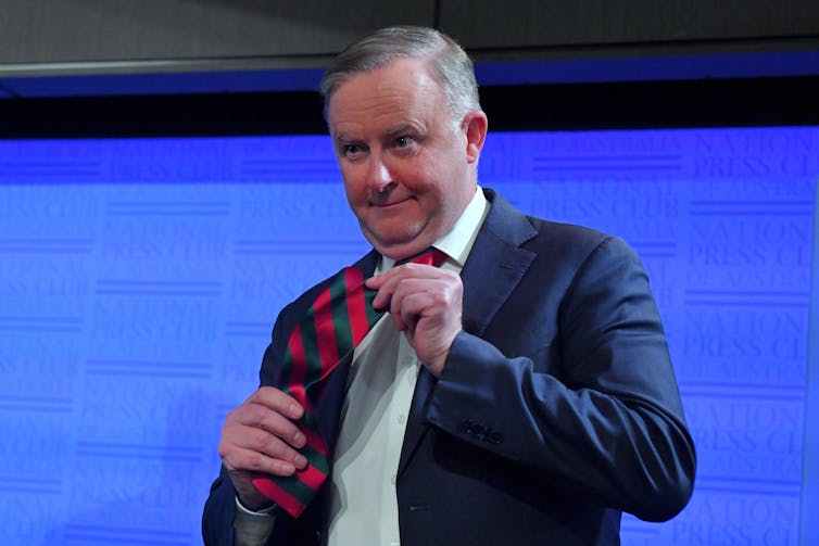 Anthony Albanese shows his red and blue necktie.