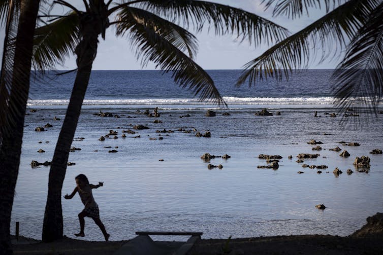 A child plays on a beach in Nauru.