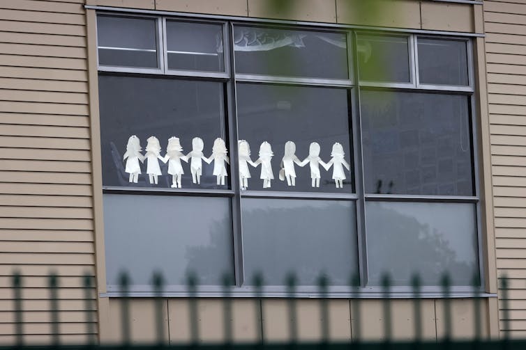 A window display at Auckland's Papatoetoe High School, showing paper cut-out figures.
