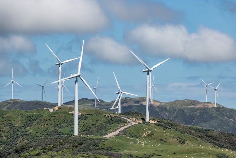 Several windmills on a hillside in New Zealand.