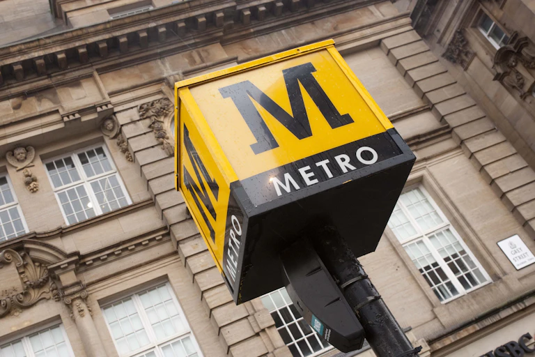Yellow metro sign in front of city building