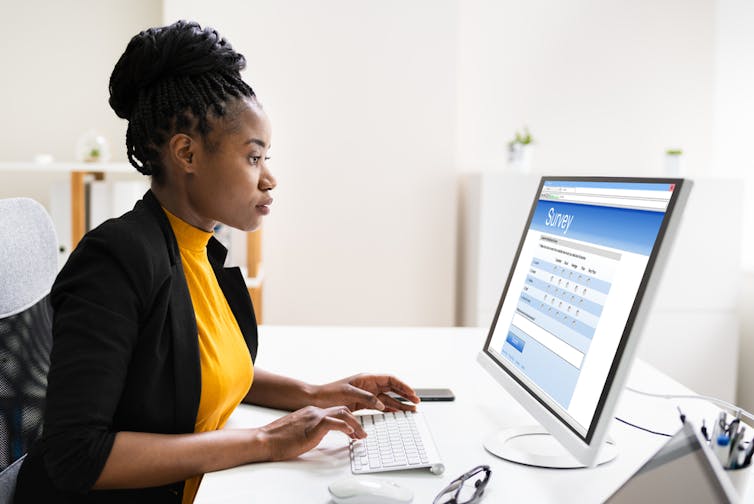 Black business woman fills out survey on computer