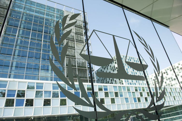 Photo of the side of a glass building with the scales of justice emblazoned on its facade