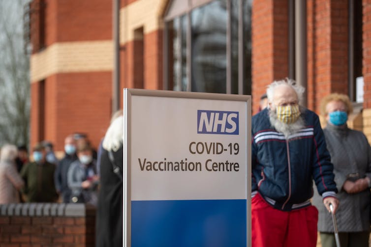 People queue at a COVID-19 vaccination centre in the United Kingdom.