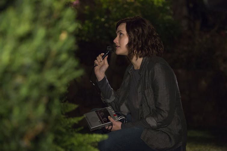 A teen talks into a tape recorder.