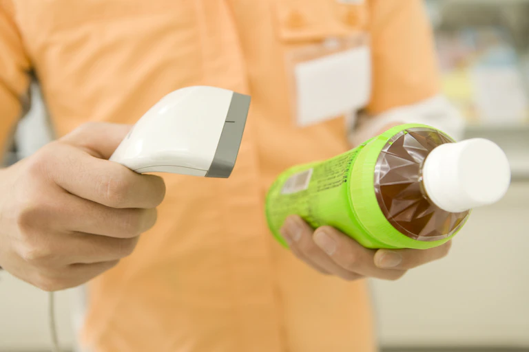 A shop clerk scans a plastic bottle.