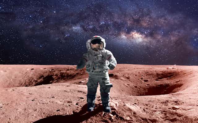 An astronaut in a space suit standing on Mars, with the Milky Way in the background.