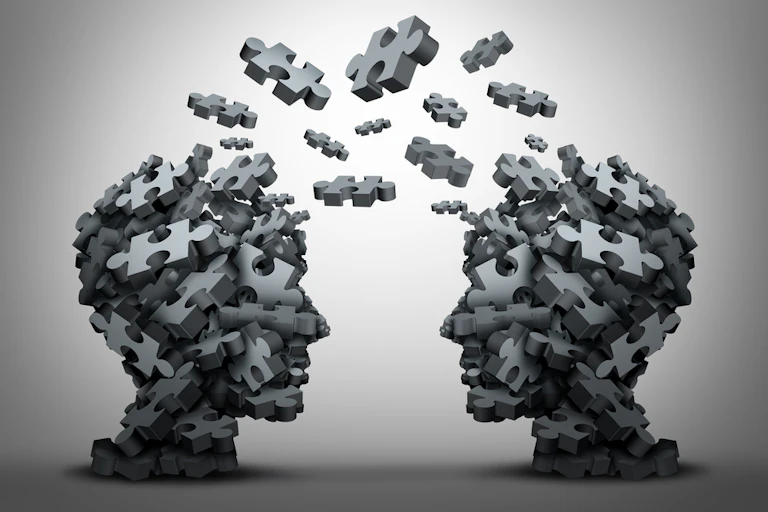 A group of jigsaw puzzle pieces, shaped as two human heads, exchange between the two heads in a 3D concept illustration.