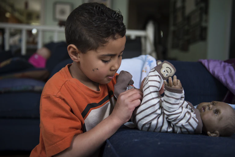 Young child dresses their doll
