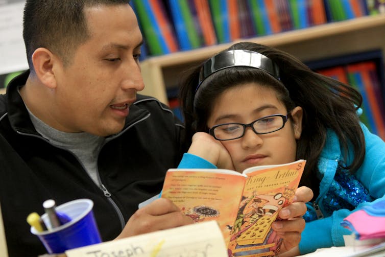 Adult reads book to child