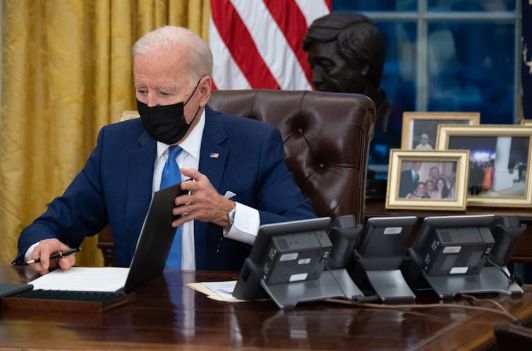 President Biden signing an executive order at his desk