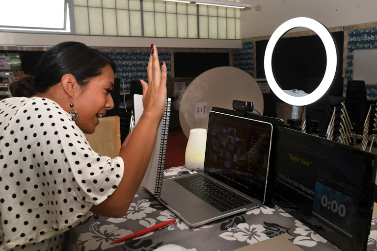 A teacher waves 'hello' to her online class.
