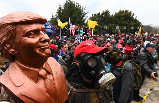 A Donald Trump supporter  wears a gas mask.