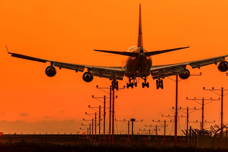 Plane lands at sunset