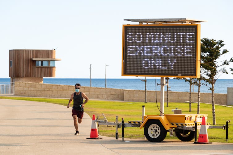 Person jogging wearing a mask in Perth