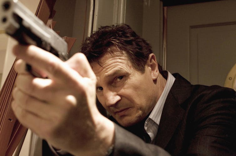 Neeson Aims A Gun.