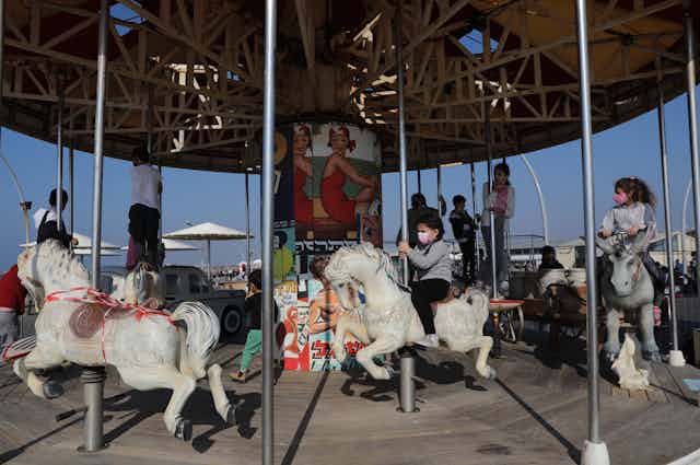Children in Tel Aviv, Israel, playing on a merry-go-round, February 2021.