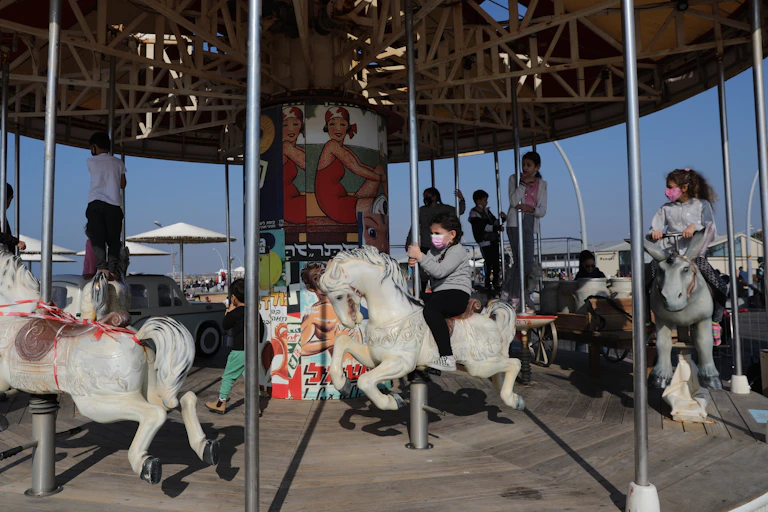 Children in Tel Aviv, Israel, playing on a merry-go-round, February 2021.