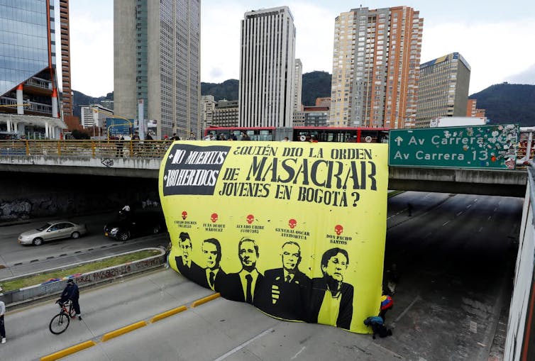 Pancarta de denuncia colgada de un puente sobre una autopista en Bogotá (Colombia)