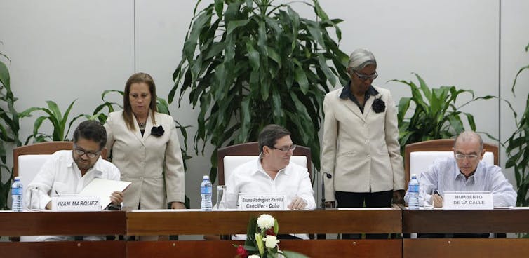 Humberto de la Calle, negociador del Gobierno colombiano, y Luciano Marín, rebelde de las FARC, firman un acuerdo de paz en la Habana (Cuba)
