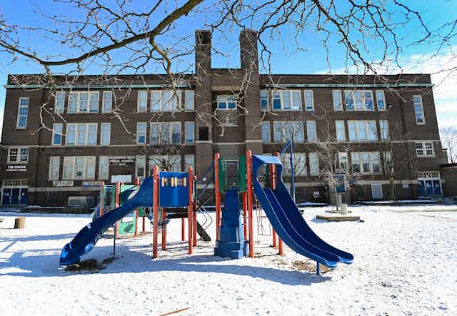 A school in winter, the empty playground is in the foreground. 