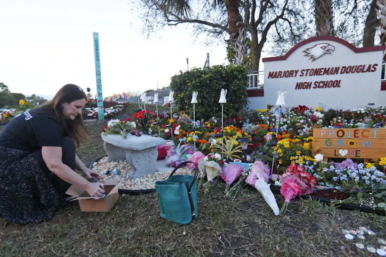 A woman places items at a memorial