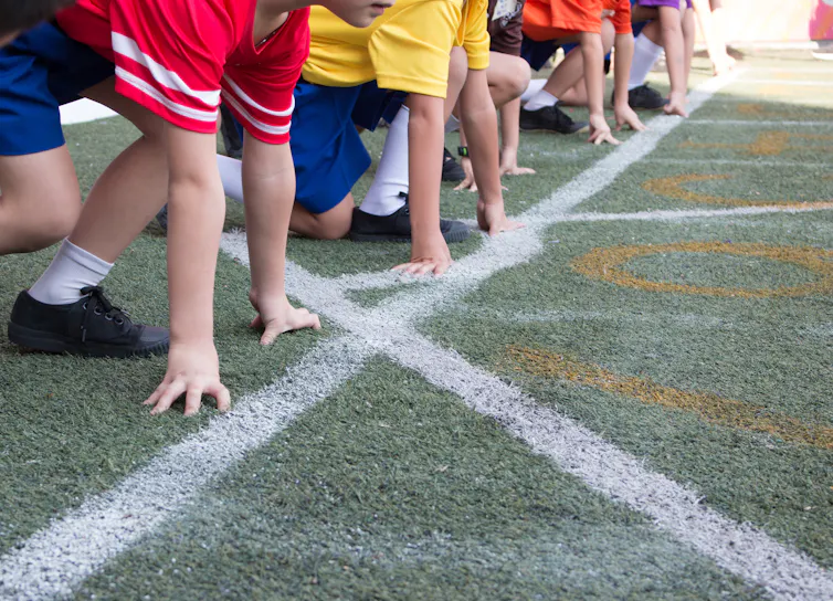 Students on a starting line on a race track.