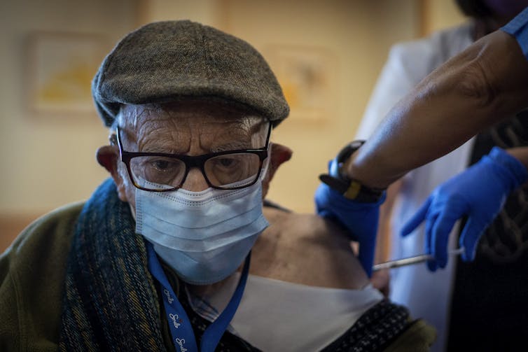 A man receives the Pfizer vaccine at his aged-care residence in Spain.