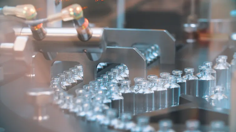 Line of vaccine vials in manufacturing facility.