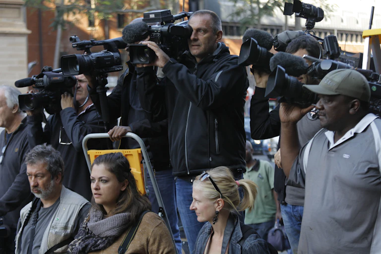 A group of people, some holding television cameras