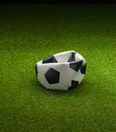 Punctured football on grass