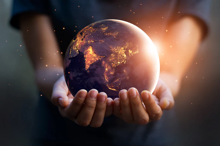 Night-time Earth globe being held by two hands.