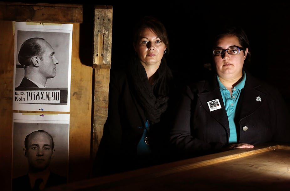 Representatives from LGBTQ+ Compass Community Center in Florida pose in front of a 2012 exhibit called Nazi Persecution of Homosexuals 1933-1945