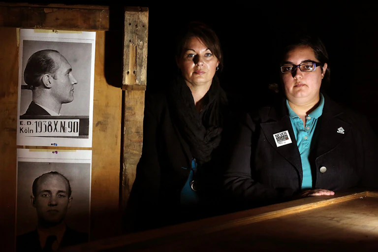 Representatives from LGBTQ+ Compass Community Center in Florida pose in front of a 2012 exhibit called Nazi Persecution of Homosexuals 1933-1945