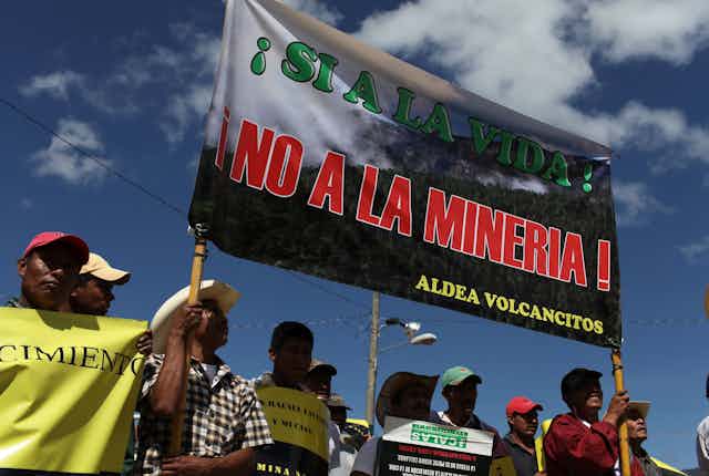 Protesters hold up an anti-mining sign.