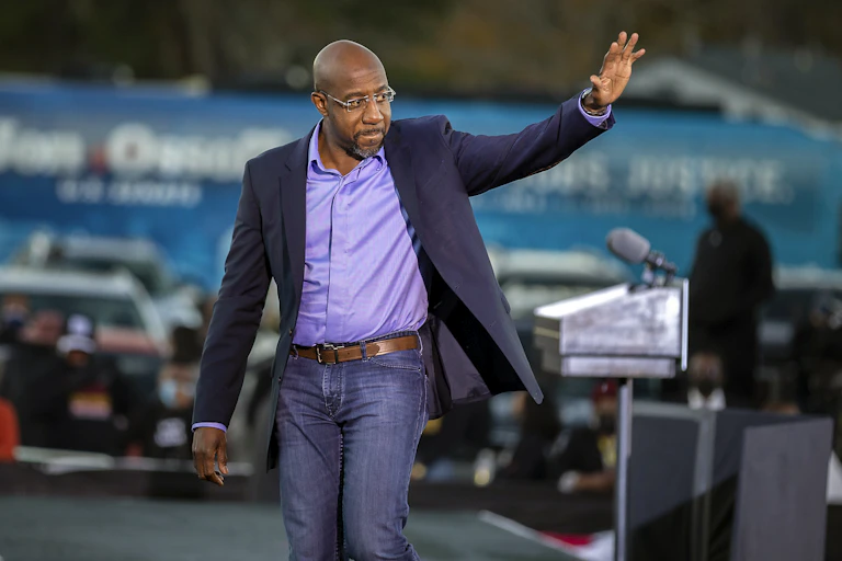 Raphael Warnock waves to a crowd of supporters