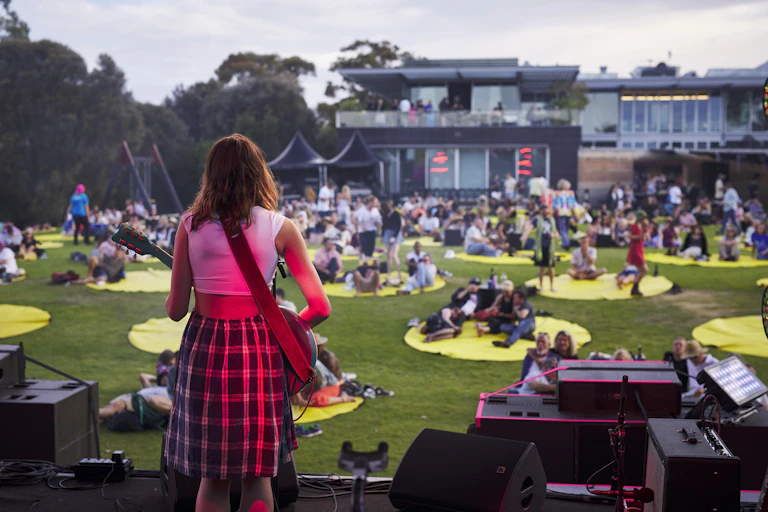 Woman on stage to spaced out crowd