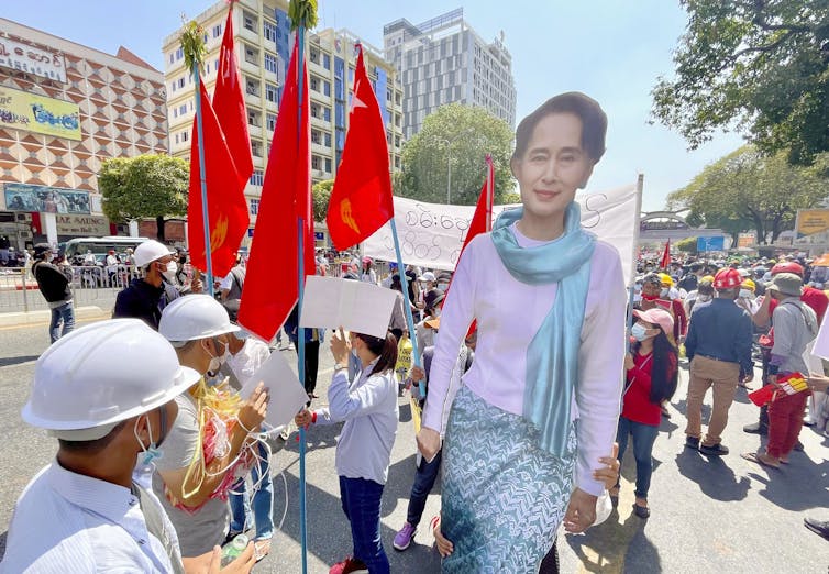 Coup protesters hold poster of Aung San Suu Kyi