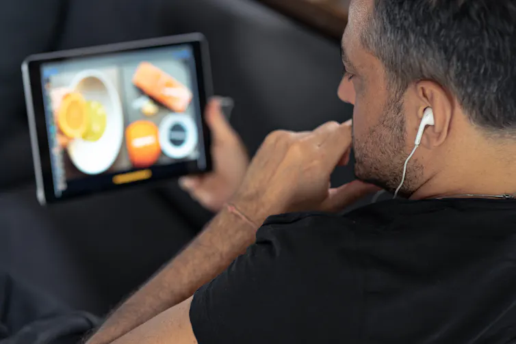 Man watches a cooking video on his tablet.