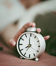 Woman hitting alarm clock