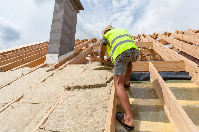 Worker fits roof insulation