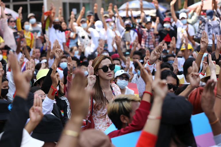 Anti-coup protesters flash the three-fingered salute during a rally